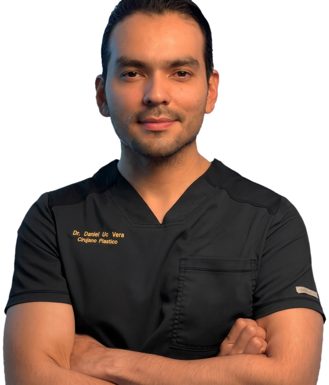 El Dr. Daniel Uc Vera de brazos cruzados, con filipina quirúrgica bordada con su nombre y especialidad.